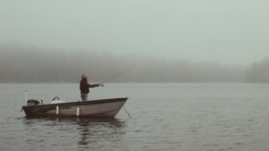 man fishing in boat social distancing